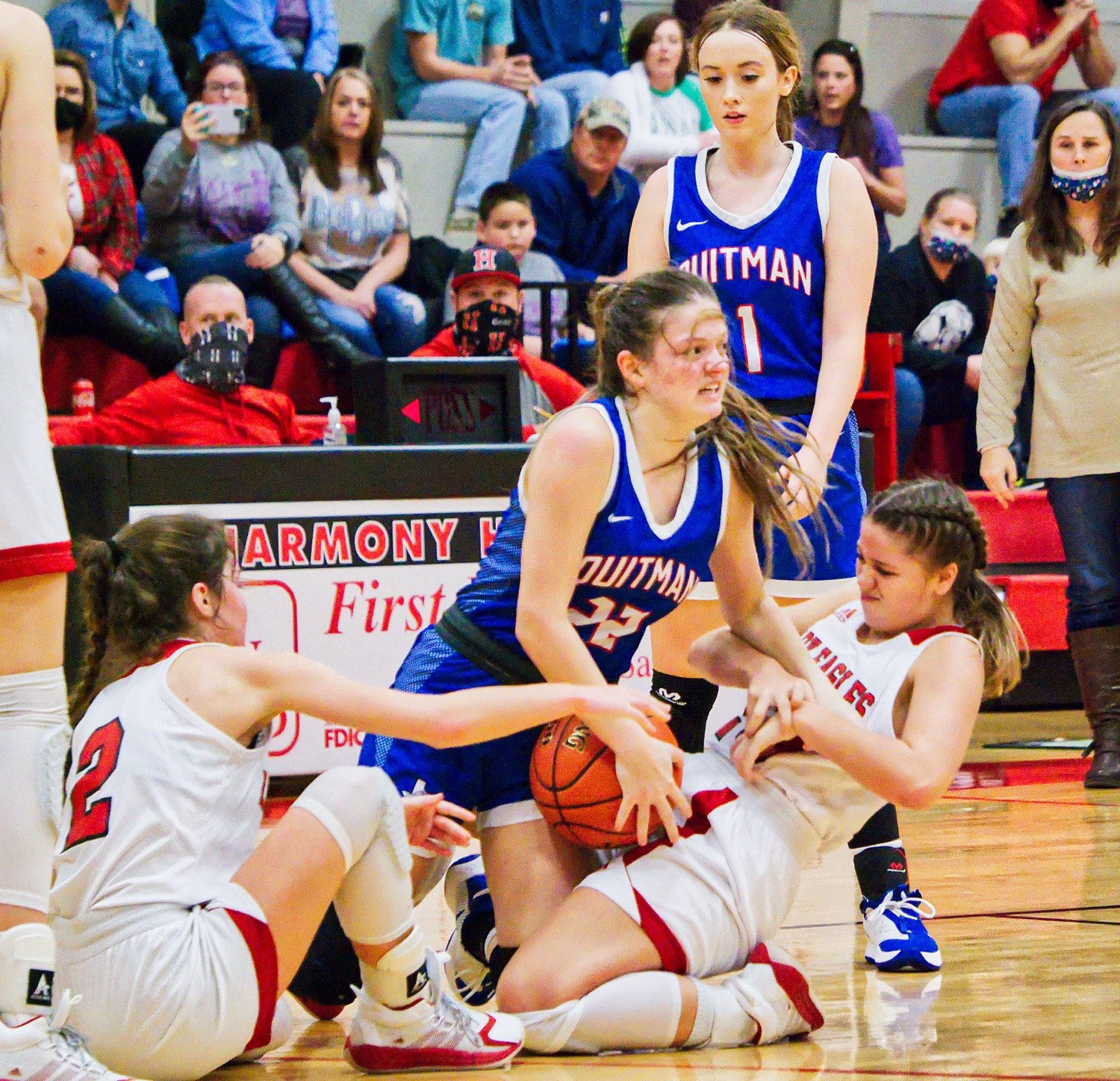 Quitman’s Maddy Pence (22) wrestles for the loose ball with Harmony players Monday. The Lady Bulldogs took a 32-31 win.